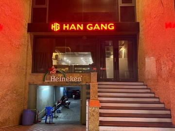 붉은 HAN GANG 간판과 매장 입구 계단